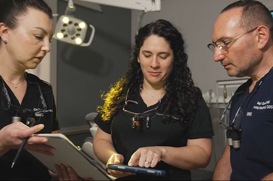 three doctors having a discussion in a dental office
