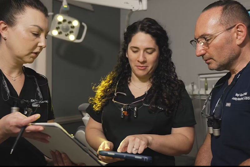 three doctors having a discussion in a dental office