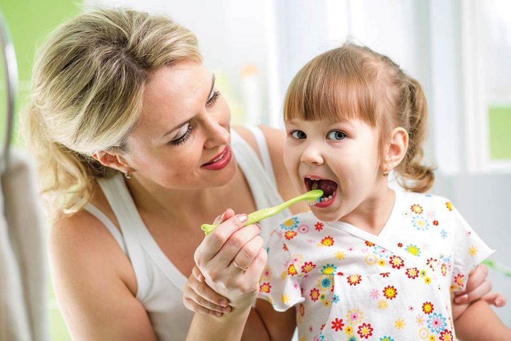 child and mother with toothbrush